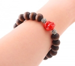 Stretchable Natural Organic Sandalwood Tibetan Bead Bracelet with Tassle and Red Buddha Head with CZ stones. Bead Diameter: 9mm. One size fits all.